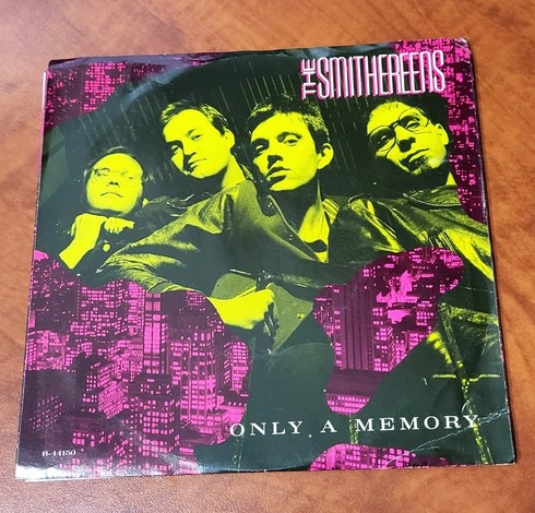 The front cover of the Smithereens' Only a Memory 45. Whole band in green with pink accents