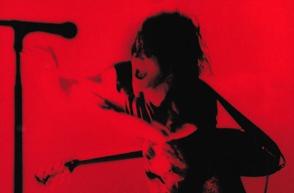 A black and red contrast washed photo of nine inch nails - guitar, microphone, etc. 