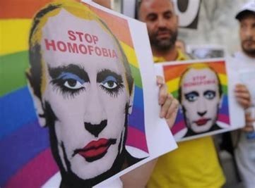 People holding 'stop homofobia' signs with Putin in makeup and a rainbow flag in the background