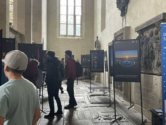 Im Kirchraum der großen gotischen Kirche stehen die Bilder und Menschen, die sie betrachten