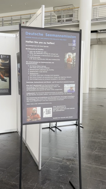 Das Video zeigt einen Blick auf einige Bilder der Ausstellung, die auf schwarzen Tafeln montiert sind. Die Bilder zeigen verschiedene Perspektiven von Schiffen und Seeleuten und am Anfang eine beschreibende Tafel.