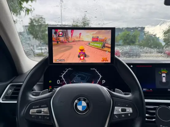 The Switch 2 with Mario Kart on it, but rested on the top of a car steering wheel